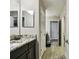 A light and bright bathroom featuring granite countertops, tile floors, and vanity with black cabinets at 11002 Sundrift Dr, Tampa, FL 33647