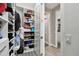 Walk-in closet filled with clothes and storage bins with easy access to doors leading to the hallway at 11002 Sundrift Dr, Tampa, FL 33647