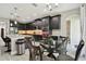 Dining room features a glass table, modern chairs and connects to the kitchen and living area at 11002 Sundrift Dr, Tampa, FL 33647