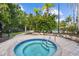 Relaxing hot tub with tile surround and stainless steel railings surrounded by lush landscaping, perfect for unwinding at 11002 Sundrift Dr, Tampa, FL 33647