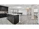Modern kitchenette featuring dark cabinets, granite counters, and open layout to game room at 11002 Sundrift Dr, Tampa, FL 33647