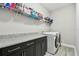 Functional laundry room with granite counters, sleek cabinets, and appliances at 11002 Sundrift Dr, Tampa, FL 33647