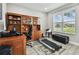 Bright home office with a large window, built-in shelving, and a treadmill at 11002 Sundrift Dr, Tampa, FL 33647