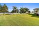 Large backyard with lush lawn, complemented by white picket fence, landscaping, and mature trees at 1109 Colson Rd, Plant City, FL 33567