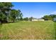 Spacious backyard with manicured lawn leading to a screened lanai and a distant view of the home at 1109 Colson Rd, Plant City, FL 33567