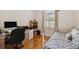 Bright bedroom with a desk and single bed, featuring hardwood floors and a large arched window at 1109 Colson Rd, Plant City, FL 33567