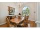 An elegant dining room featuring a wooden table, chandelier, and arched window with plantation shutters at 1109 Colson Rd, Plant City, FL 33567