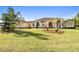 Sprawling single-story home featuring a manicured front lawn and elegant architectural details with pillars at 1109 Colson Rd, Plant City, FL 33567