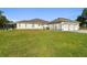 Back exterior view of home with screened-in porch and three car garage on expansive lawn at 1109 Colson Rd, Plant City, FL 33567