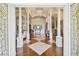 Grand foyer with soaring ceilings, decorative columns, hardwood floors, and an ornate chandelier at 1109 Colson Rd, Plant City, FL 33567