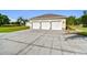 Attached three-car garage showcasing white doors and decorative sconces on a concrete driveway at 1109 Colson Rd, Plant City, FL 33567