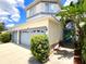 Inviting home featuring a two-car garage and covered entryway with a pop of tropical landscaping at 11122 Kempton Vista Dr, Riverview, FL 33579