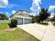 Spacious home showcasing a large driveway leading to a two-car garage, surrounded by lush greenery at 11122 Kempton Vista Dr, Riverview, FL 33579