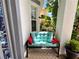 Close up of the porch's bench seating with a view of the front yard's tropical landscaping at 11122 Kempton Vista Dr, Riverview, FL 33579