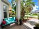 Inviting front porch featuring a comfortable bench surrounded by lush tropical plants and a manicured lawn at 11122 Kempton Vista Dr, Riverview, FL 33579