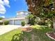 Well-manicured lawn with mature trees framing the home's facade and three-car driveway at 11122 Kempton Vista Dr, Riverview, FL 33579
