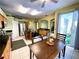 An open kitchen with an island and dining area, brightened by natural light from the sliding glass door at 11122 Kempton Vista Dr, Riverview, FL 33579