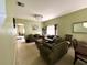 Cozy living room and dining area featuring comfortable seating, a chandelier, and ample natural light at 11122 Kempton Vista Dr, Riverview, FL 33579