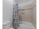 Bathroom with tiled shower-tub combination and modern patterned shower curtain at 11219 Paddock Manor Ave, Riverview, FL 33569