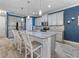 A kitchen with gray cabinets, granite countertops, and an island with white chairs at 11219 Paddock Manor Ave, Riverview, FL 33569