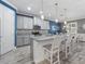 A kitchen with gray cabinets, a gray backsplash, granite countertops, an island, and light-colored flooring at 11219 Paddock Manor Ave, Riverview, FL 33569