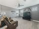 A gray living room with a ceiling fan, a TV, and two leather recliners at 11219 Paddock Manor Ave, Riverview, FL 33569