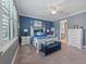 Main bedroom featuring blue accent wall, a white bed frame and side tables, plus an end-of-bed bench at 11219 Paddock Manor Ave, Riverview, FL 33569