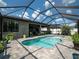 Beautiful screened pool area featuring a uniquely shaped pool surrounded by lush greenery and outdoor plants at 11219 Paddock Manor Ave, Riverview, FL 33569