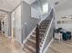 Hallway view of stairs with decorative railing, gray walls, and artwork leading to an upstairs area with a chair at 11219 Paddock Manor Ave, Riverview, FL 33569