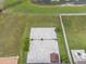 Aerial view of a backyard featuring a large patio, green grass, and mature trees near a lake at 11308 Chilly Water Ct, Riverview, FL 33569