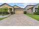 Front of the home featuring a brick driveway, desert landscaping, and neutral exterior paint colors at 11308 Chilly Water Ct, Riverview, FL 33569