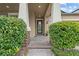Front door entrance featuring a tiled front porch and mature shrubbery at 11308 Chilly Water Ct, Riverview, FL 33569