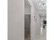 Hallway with decorative light fixture, view of the kitchen, and an open doorway to a carpeted room at 11308 Chilly Water Ct, Riverview, FL 33569