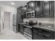 Modern kitchen featuring stainless steel appliances, dark cabinetry, and granite countertops at 11308 Chilly Water Ct, Riverview, FL 33569