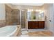 Stylish bathroom with a walk-in shower, soaking tub, and dual sinks at 11343 Dancing River Dr, Venice, FL 34292