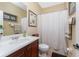 Neutral bathroom features a vanity with ample lighting, shower with curtain, and decorative accents at 11343 Dancing River Dr, Venice, FL 34292