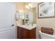 Compact bathroom includes a vanity, large mirror, and ample lighting for a bright and functional space at 11343 Dancing River Dr, Venice, FL 34292