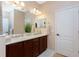 Bright bathroom featuring dual sinks, neutral walls, and white trim at 11343 Dancing River Dr, Venice, FL 34292
