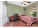 Green bedroom with desk and bed, wood-look flooring, ceiling fan, and natural light from the window at 11343 Dancing River Dr, Venice, FL 34292