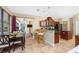 Beautiful kitchen features dark wood cabinetry, stainless steel appliances, breakfast bar and open concept dining at 11343 Dancing River Dr, Venice, FL 34292