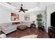 Cozy living room with modern decor, plush seating, tray ceiling, and hardwood flooring at 11343 Dancing River Dr, Venice, FL 34292