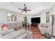 Bright living room features hardwood flooring, ceiling fan, and large windows for natural light at 11343 Dancing River Dr, Venice, FL 34292