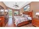 Relaxing main bedroom with tray ceilings, hardwood floors, sliders to the pool area, and a ceiling fan at 11343 Dancing River Dr, Venice, FL 34292