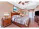 Cozy main bedroom with hardwood floors, a tray ceiling, an attractive painting, and coordinating decor at 11343 Dancing River Dr, Venice, FL 34292
