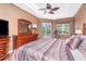 Relaxing main bedroom with tray ceilings, hardwood floors, sliders to the pool area, and a ceiling fan at 11343 Dancing River Dr, Venice, FL 34292