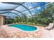 Enclosed pool area featuring brick-paver flooring, comfortable seating, and a beautiful view of the trees at 11343 Dancing River Dr, Venice, FL 34292