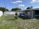 Spacious backyard with white fence, green lawn, landscaping and room for entertaining at 1144 Rushmore Dr, Holiday, FL 34690