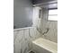 Bathroom featuring marble-look tile in the shower and a silver towel rack at 1144 Rushmore Dr, Holiday, FL 34690
