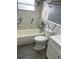 Close-up of a bathroom featuring marble-look tiles in shower, toilet and vanity area at 1144 Rushmore Dr, Holiday, FL 34690