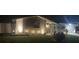 Home exterior at night with charming lighting, new paint and landscaping at 1144 Rushmore Dr, Holiday, FL 34690